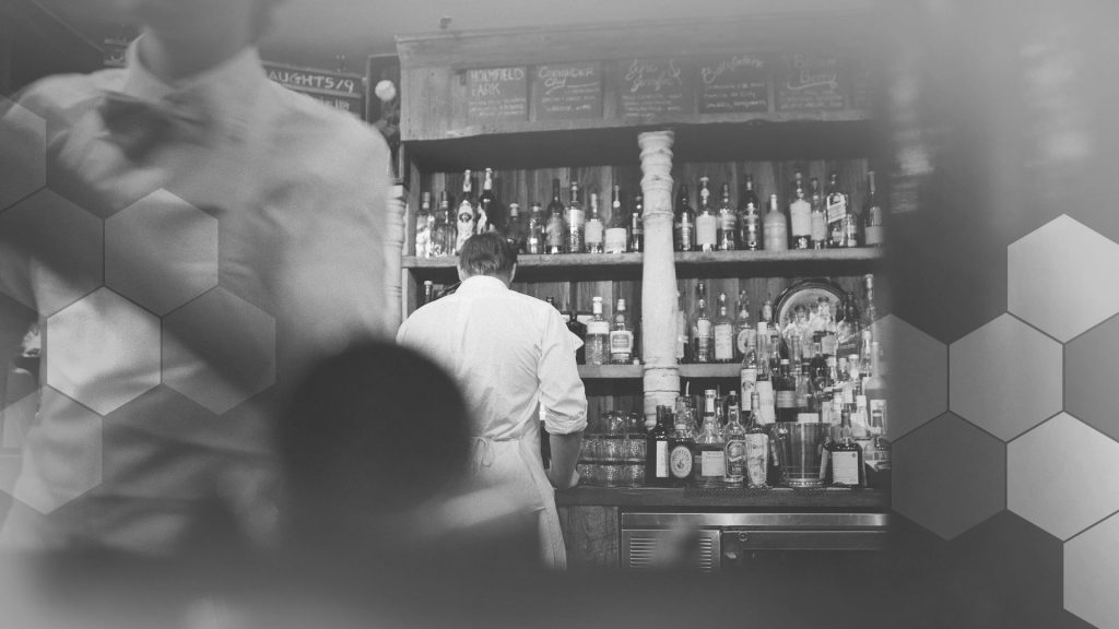 A monochrome scene at a busy restaurant bar.